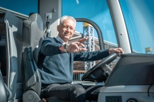 Busfahrer DER SCHMIDT GRUPPE am Steuer eines Busses der freundlich grüßt