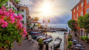 Sonnenaufgang im Hafen von Limone am Gardasee mit kleinen Schiffen in einem kleinen Hafen