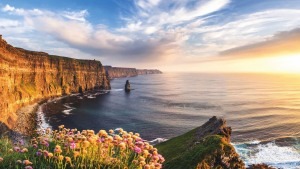 Sonnenuntergang an einer Klippe in Irland mit Blick auf die Küste und das Meer auf der rechten Seite