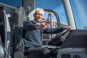 Busfahrer in einem DER SCHMIDT Busse grüßt freundlich